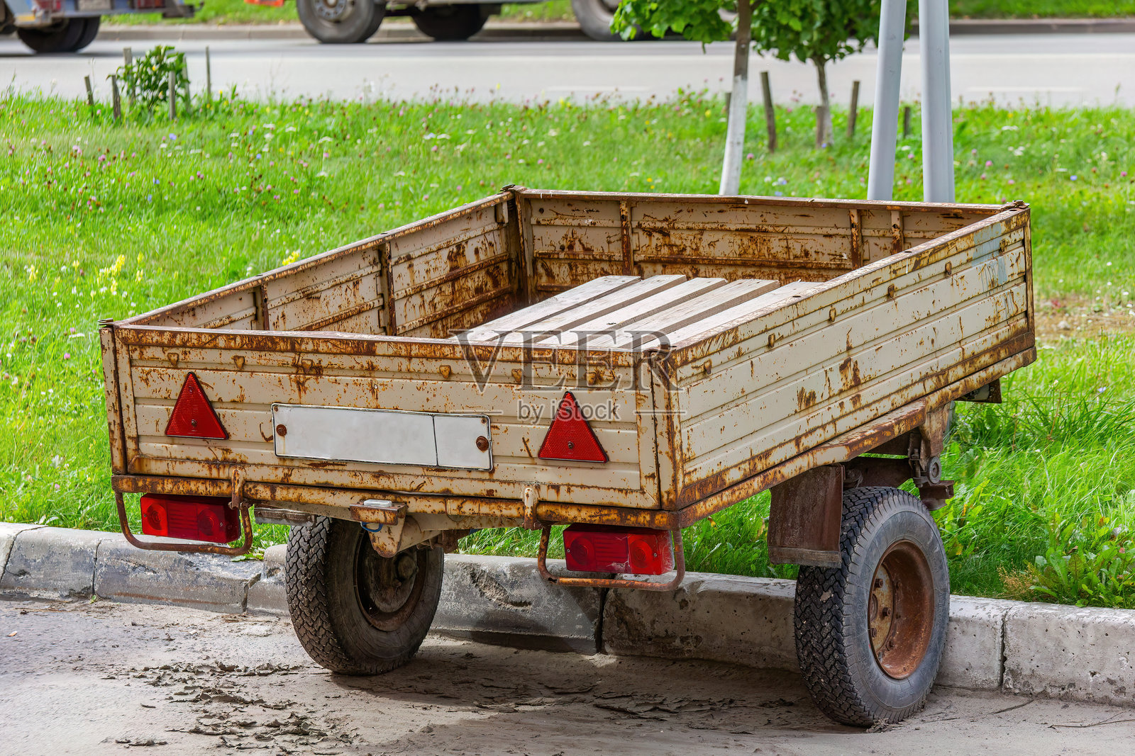 生锈的实用拖车停靠在草地附近照片摄影图片