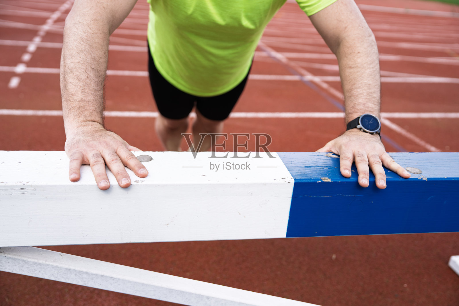 运动员在跑道上的障碍物上做俯卧撑照片摄影图片