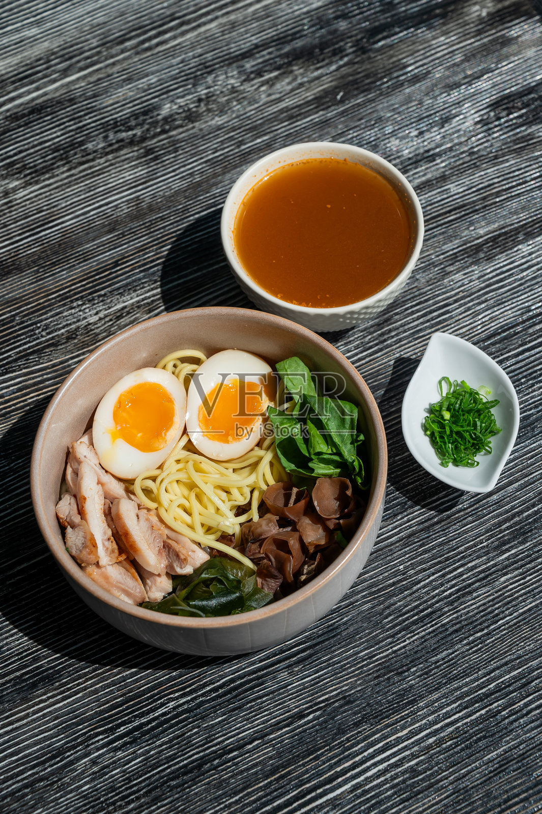 咖啡馆里的拉面汤。汤底单独盛放。照片摄影图片