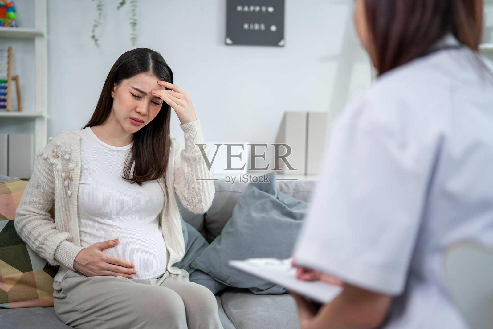 亚洲孕妇在母婴健康中心咨询医生。迷人的准妈妈在产前护理诊所接受支持和指导，度过怀孕期间的挑战时刻。照片摄影图片