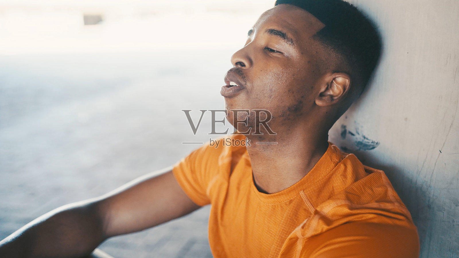 疲惫的黑人男性在城市中休息，进行健康恢复和锻炼。户外放松，非洲人进行训练，健康而疲惫，经历锻炼后的疲劳和呼吸。照片摄影图片