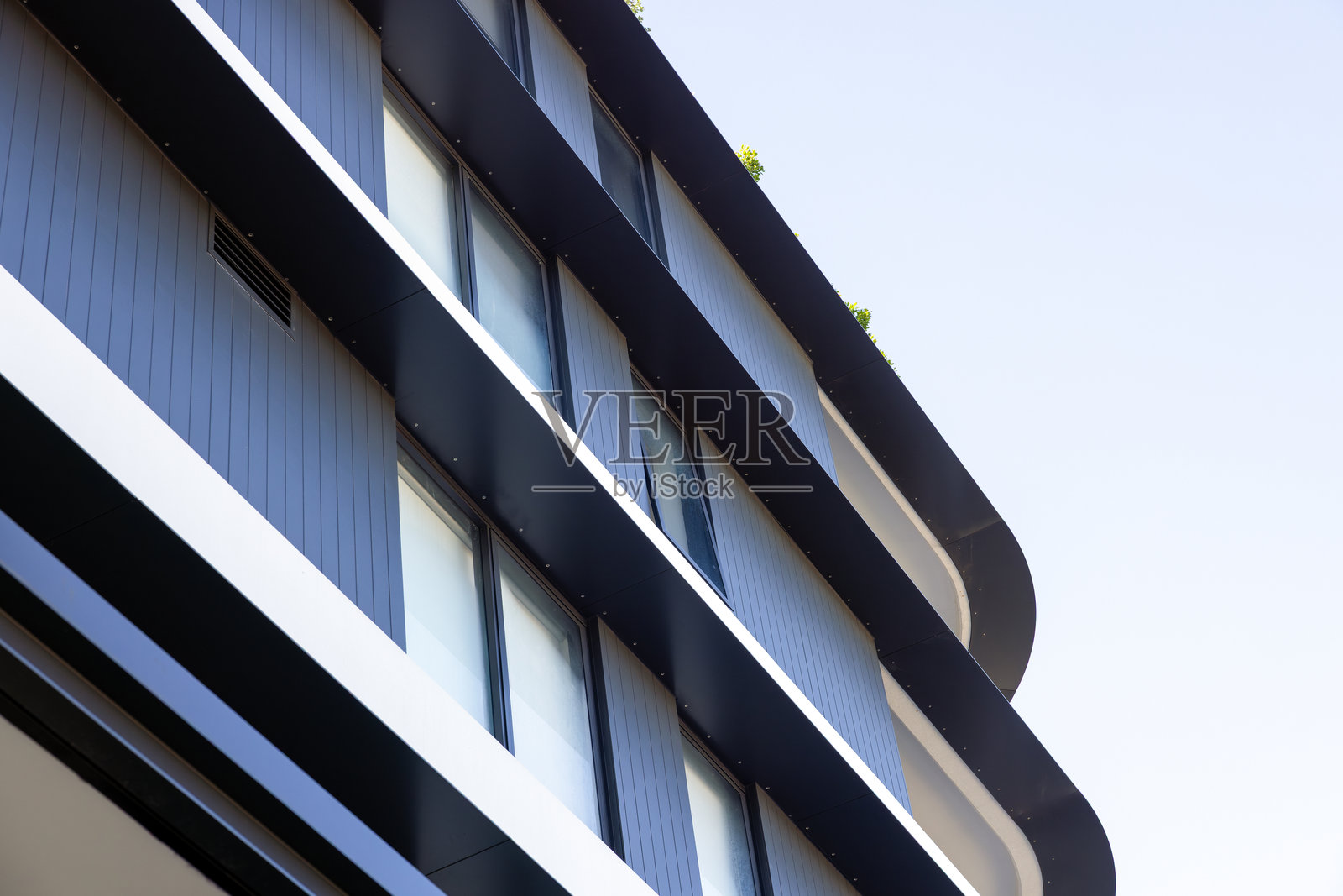 阳光下的现代公寓建筑特写，顶部部分，背景留有空白空间照片摄影图片