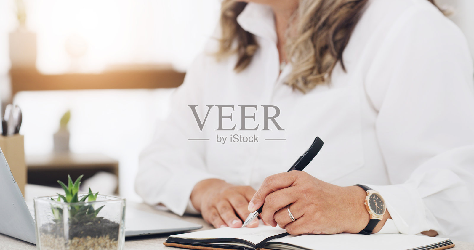 办公室里，商务女性的手在写字，旁边有笔记本，用于安排日程、任务和日历规划。约会提醒、会议计划和清单，适合个人的日记、笔记和议程。照片摄影图片