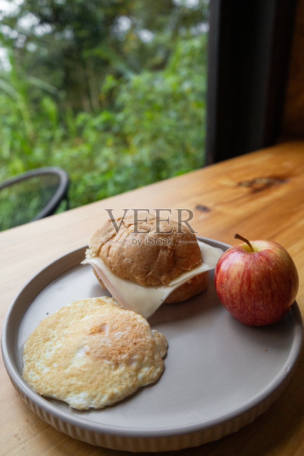 盘子里有奶酪三明治、新鲜的红苹果和金黄色的煎饼，这是一顿美味且均衡的早餐。照片摄影图片