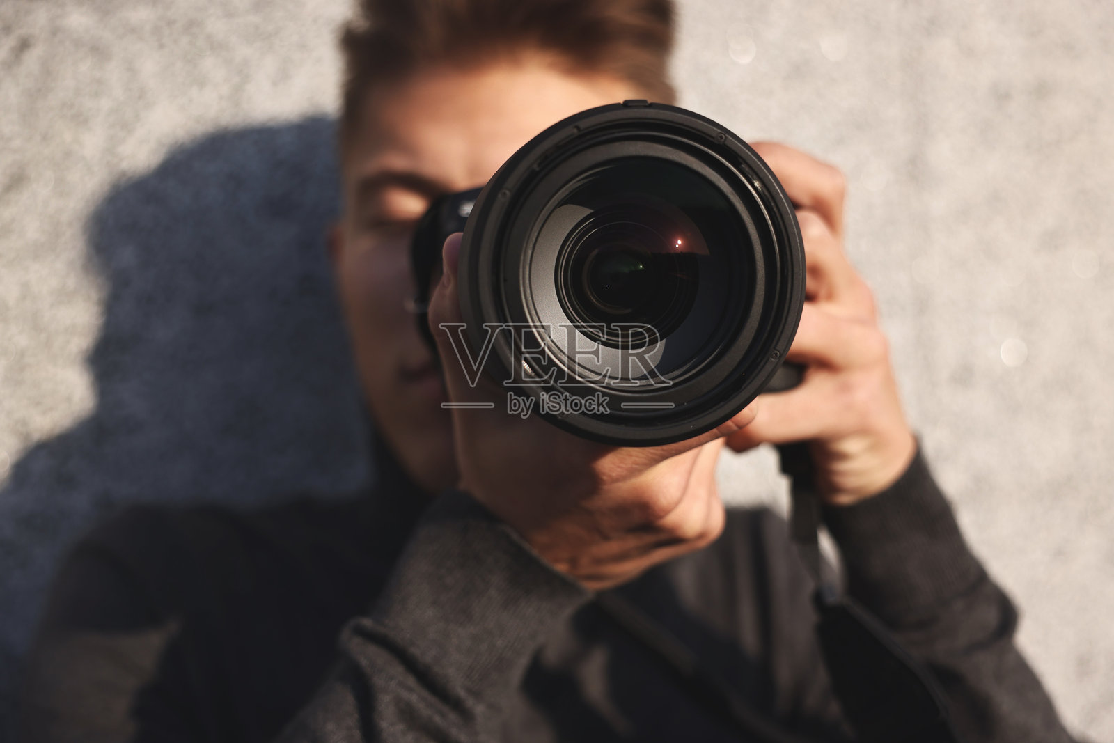 专业摄影师在户外用相机拍照，选择性对焦照片摄影图片