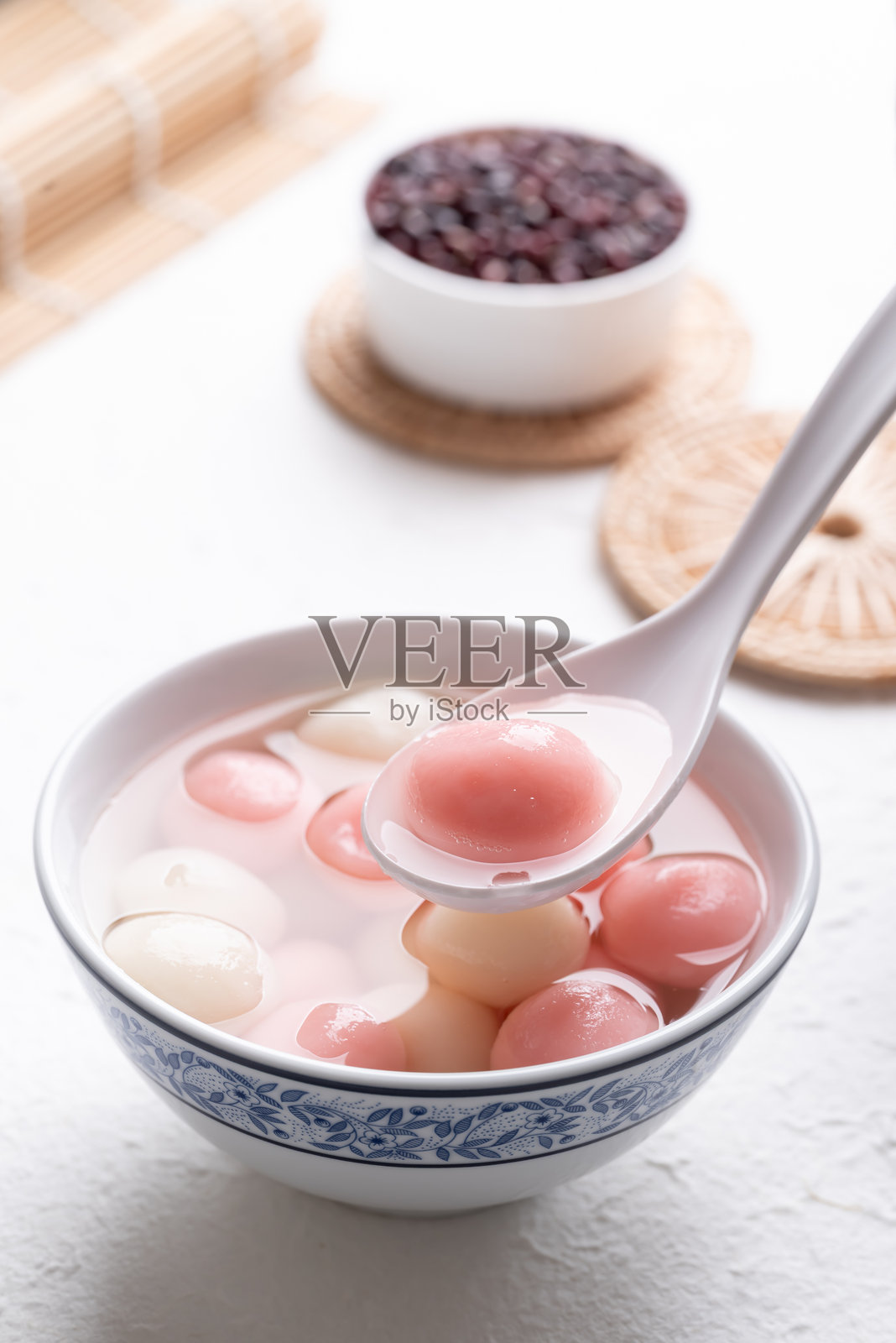 汤圆（中国甜点），白色背景上的粉色糯米球浸在糖浆中照片摄影图片