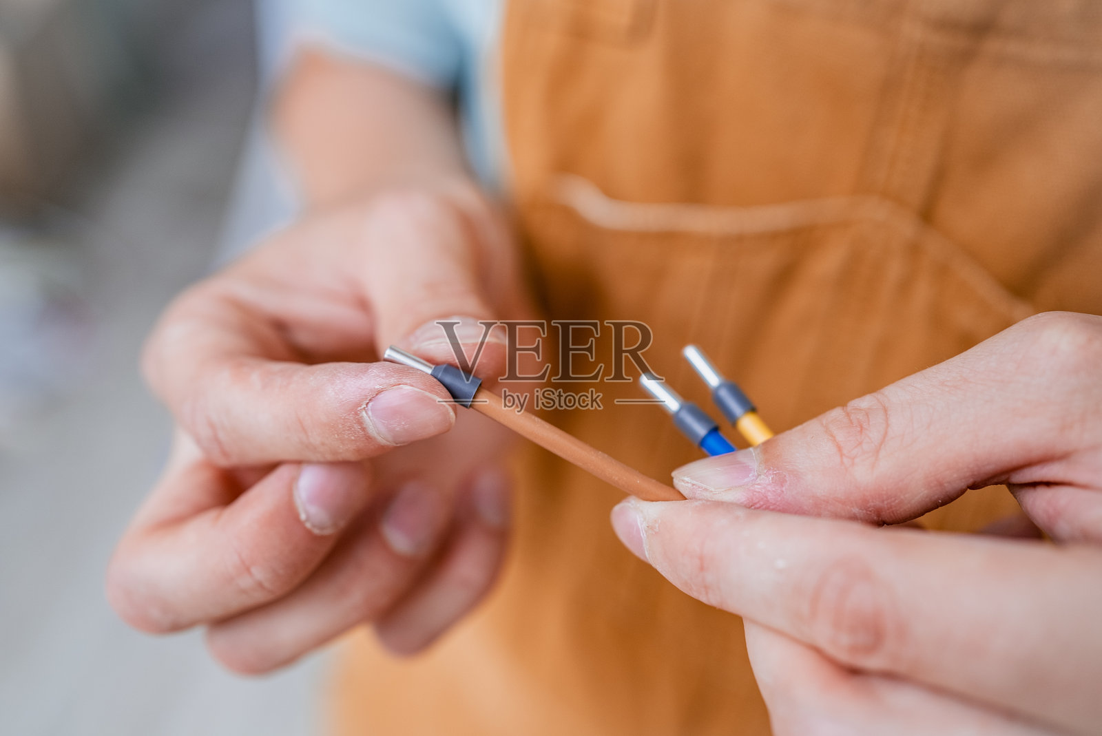 经验丰富的电工小心地将绝缘电线连接到电炉上，确保在精确安装电器时遵循工作场所安全标准。照片摄影图片