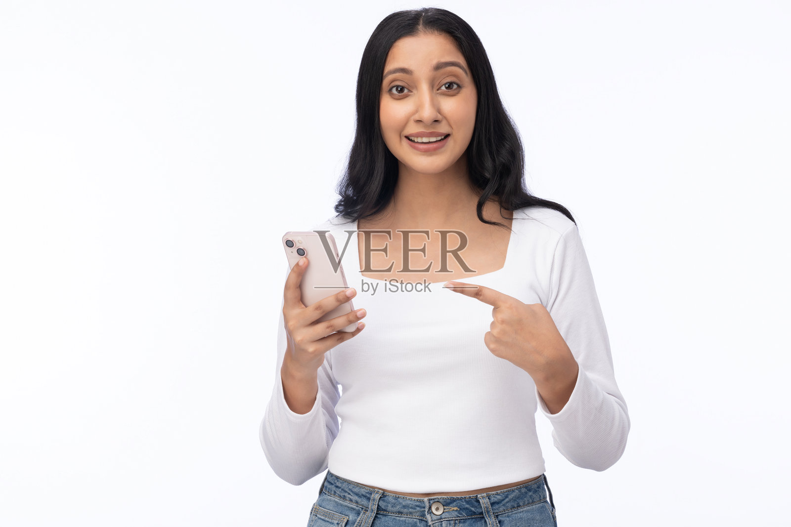 年轻女性穿着现代服装，使用手机的肖像，背景为白色。照片摄影图片