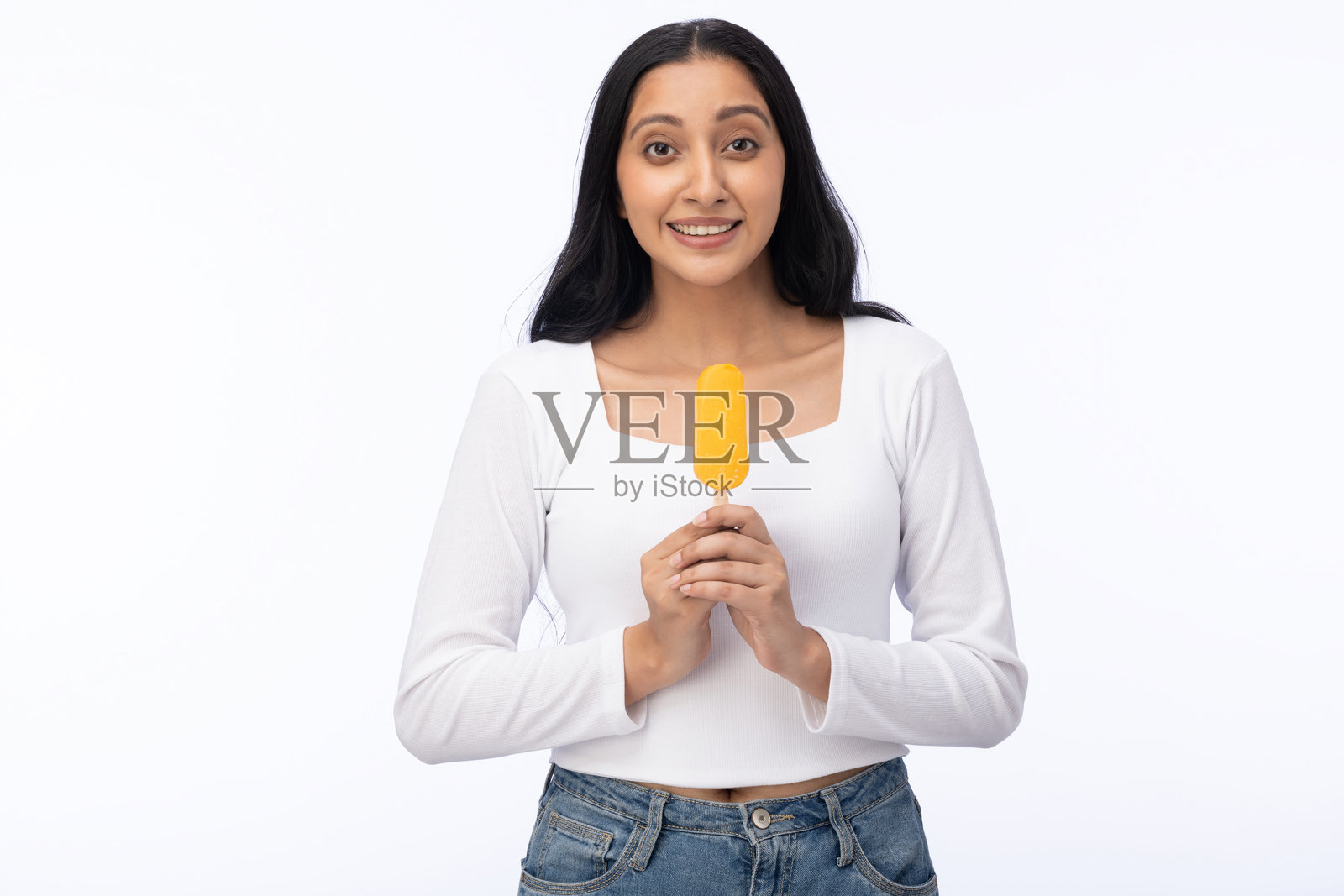 年轻女性穿着现代服装，享用芒果冰淇淋的肖像，背景为白色。照片摄影图片