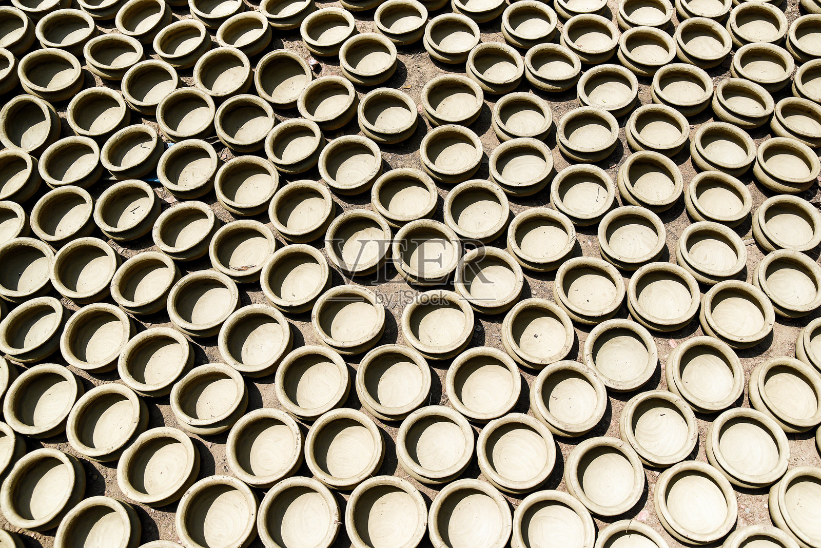 阳光下排列的均匀陶土陶器特写照片摄影图片