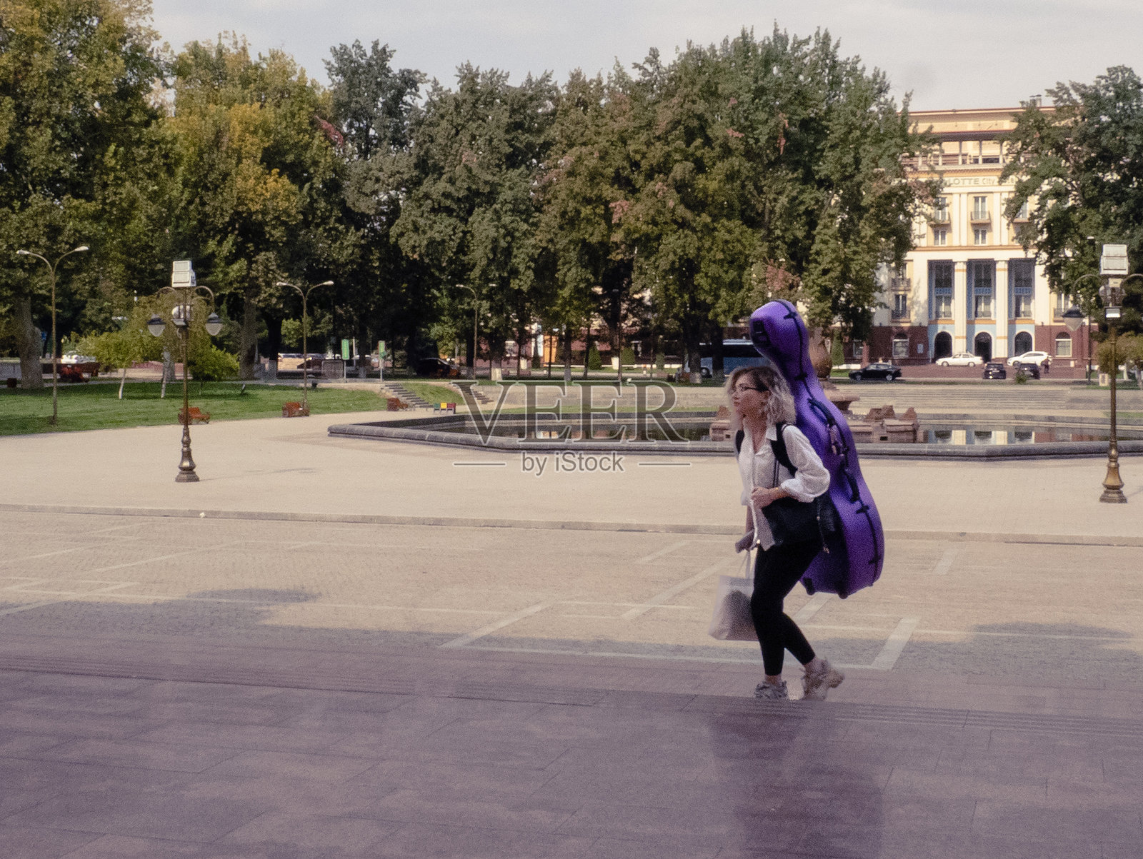 一个女孩提着大提琴走进国家剧院的排练室照片摄影图片