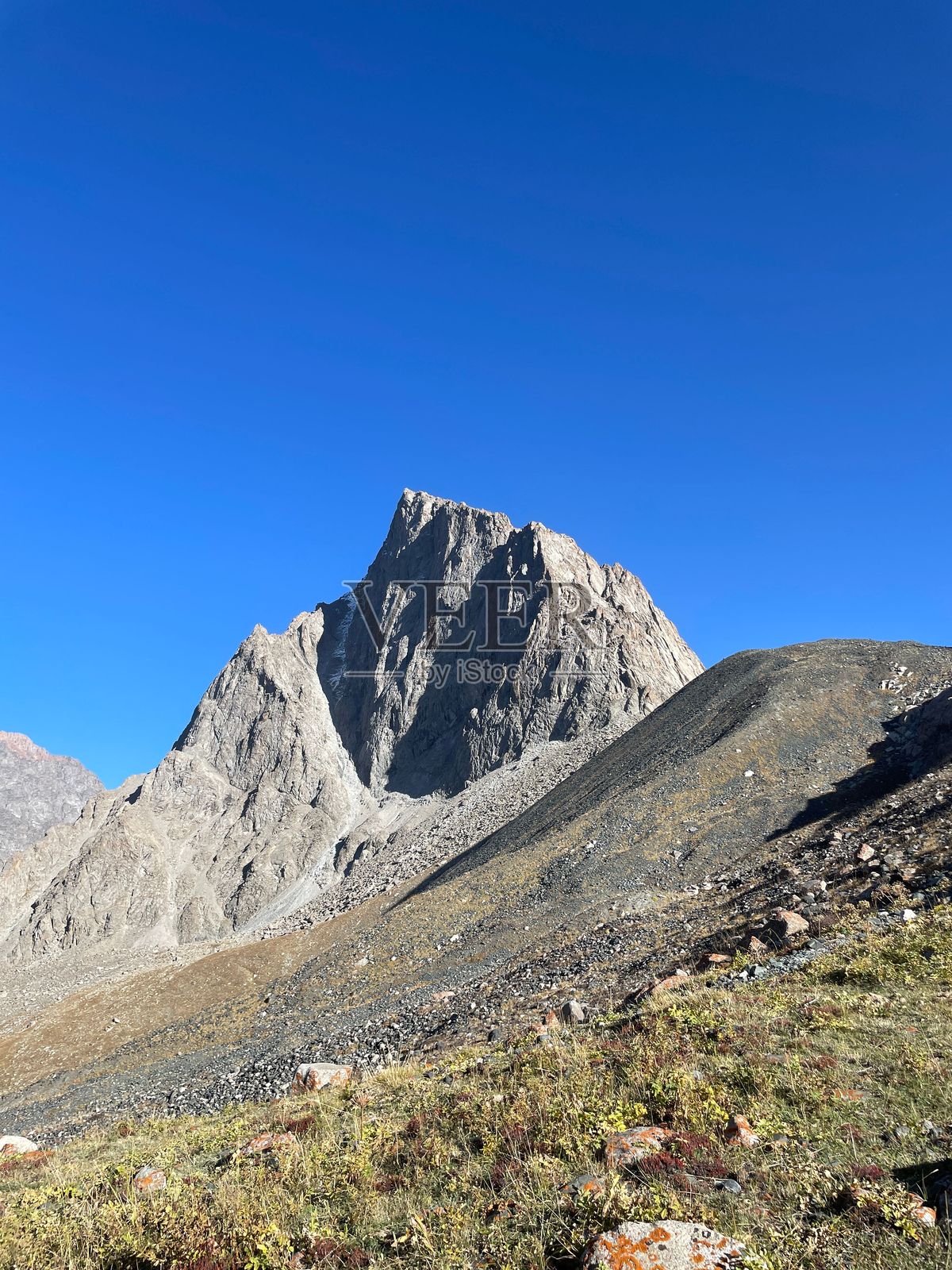 雄伟的山峰在晴朗的蓝天下。照片摄影图片