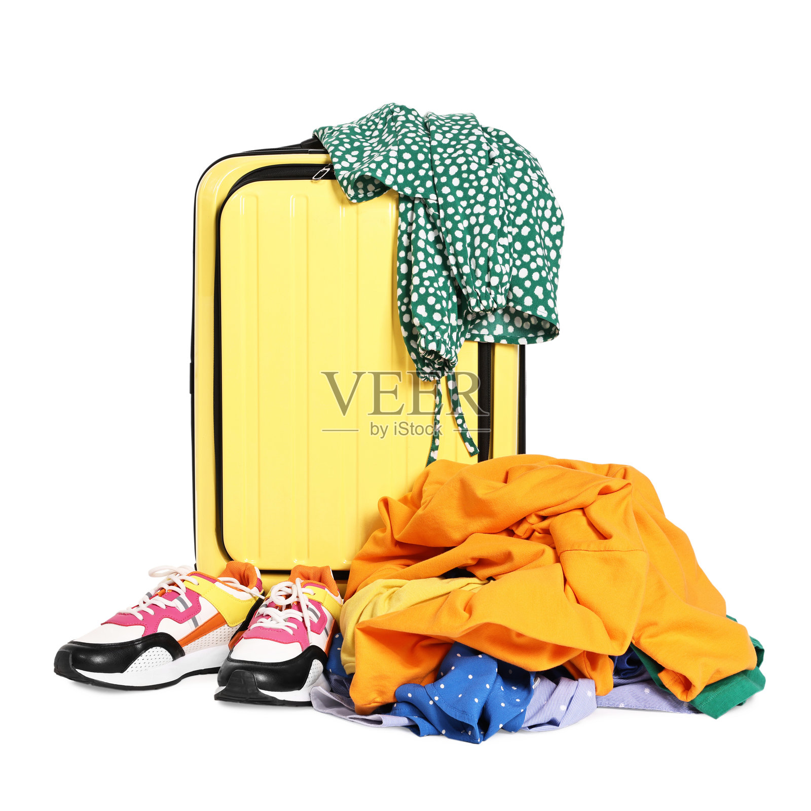 黄色行李箱、堆放的各种杂乱衣物和运动鞋，孤立在白色背景上照片摄影图片