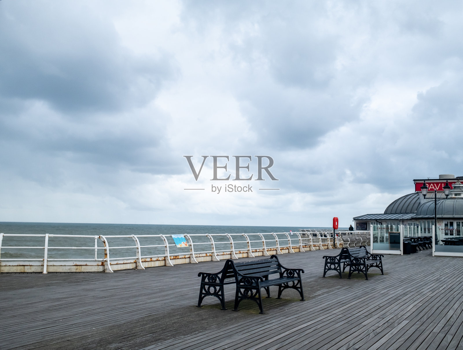 阴云密布的早晨，克罗默码头上的长椅照片摄影图片