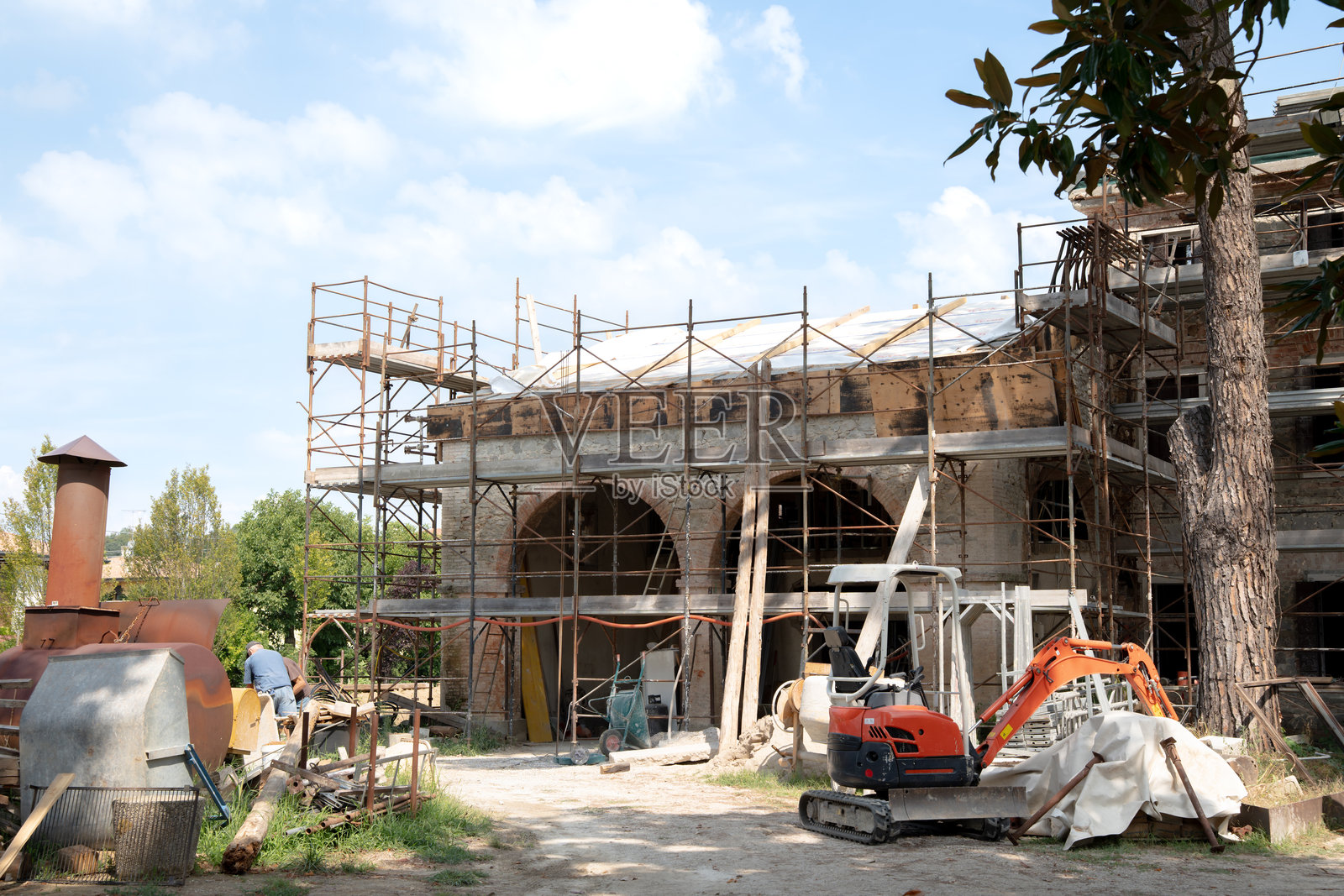 地中海历史住宅翻修的建筑工地，砖房被脚手架环绕照片摄影图片