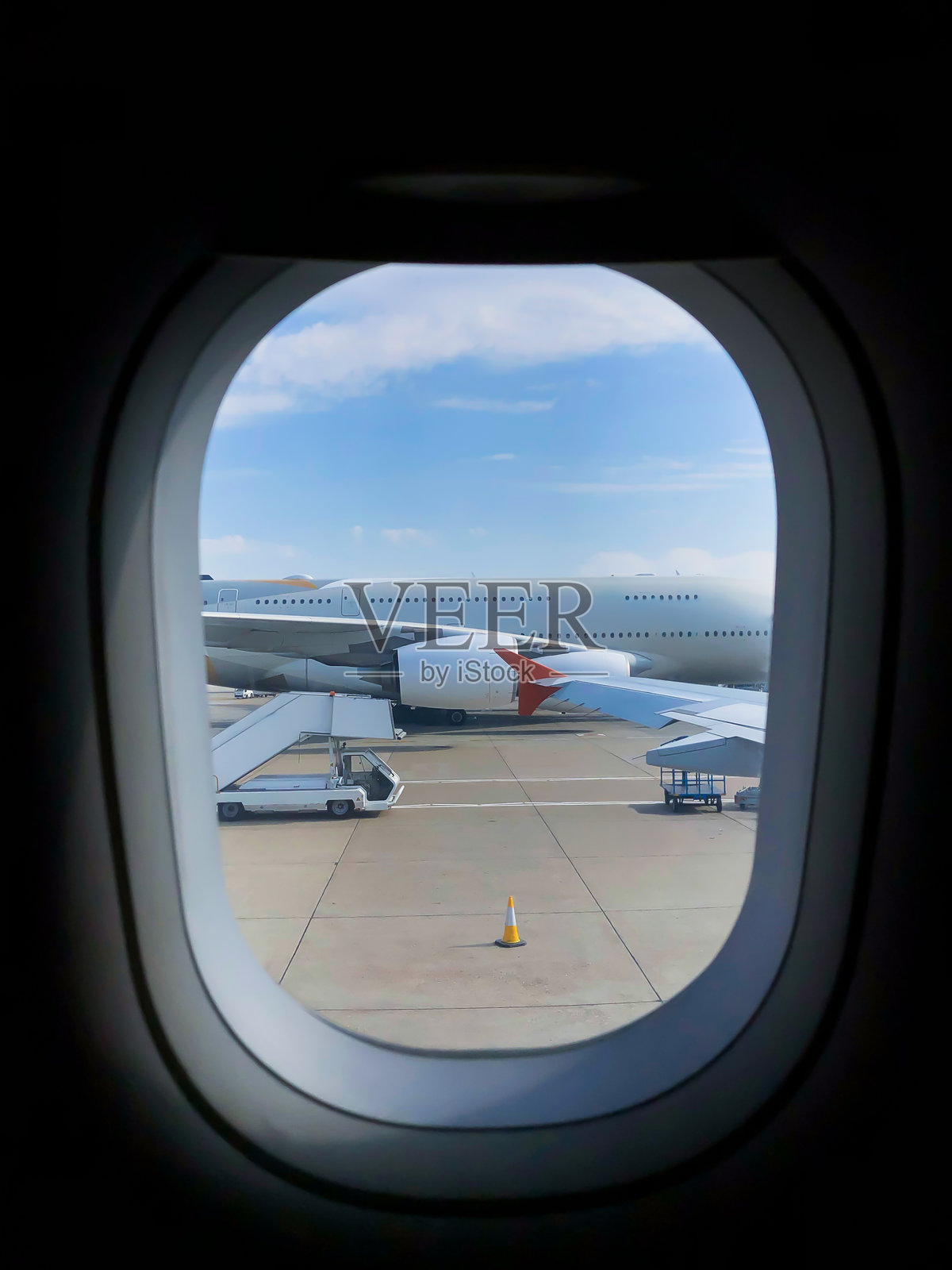 从飞机窗户看到的机场和跑道，视角是最大的飞机A380。乘客正在登机。照片摄影图片