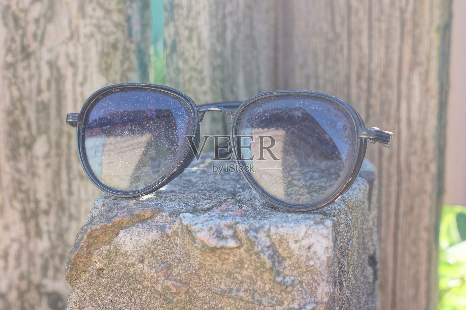 一副黑色塑料太阳镜放在灰色木桌上照片摄影图片