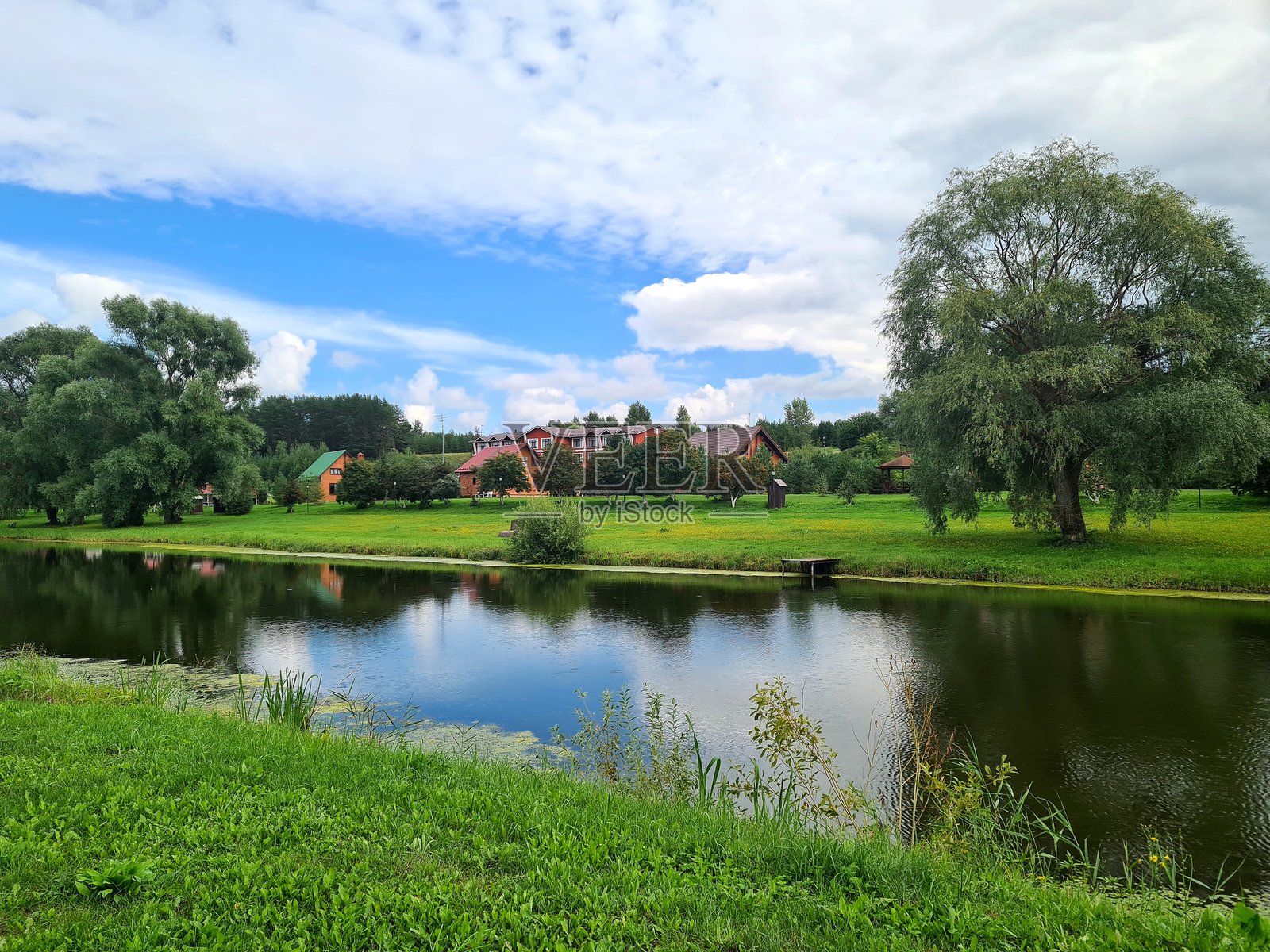 小池塘旁边有小屋和树林照片摄影图片