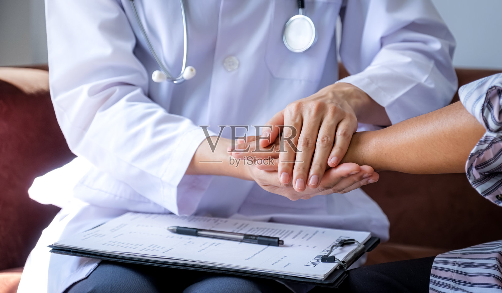 医生握着患者的手，鼓励并解释体检结果，医疗检查概念照片摄影图片