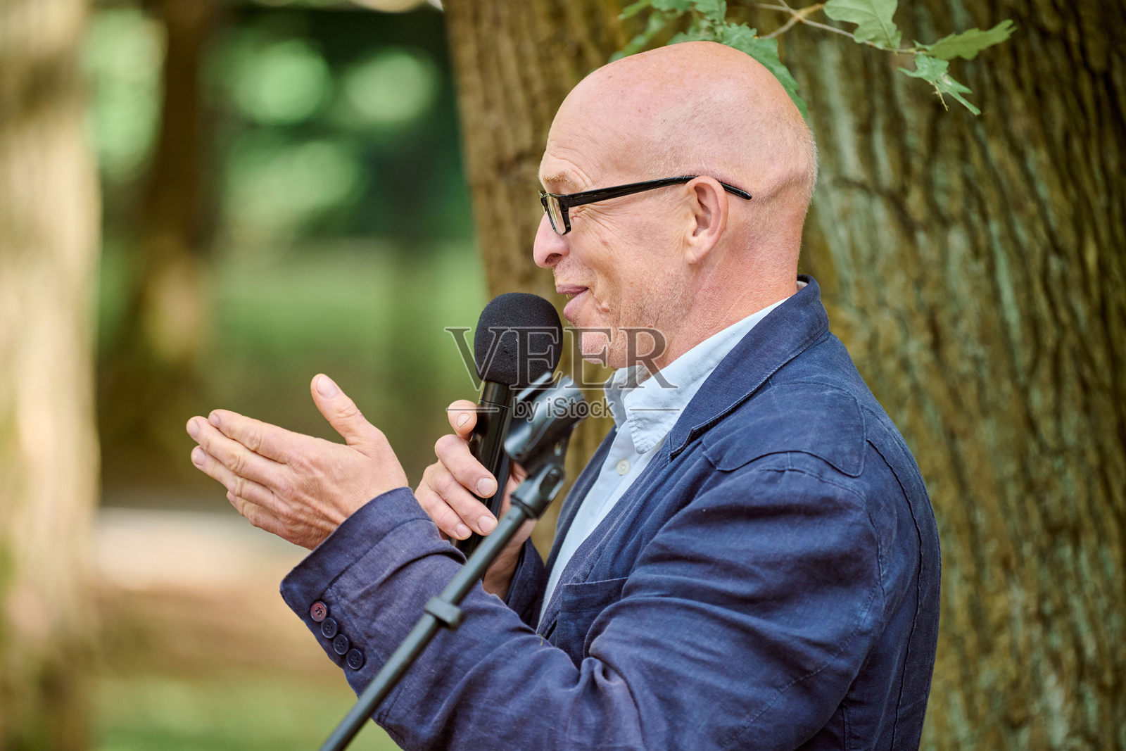 光头成熟男士在户外讲解琥珀珠宝照片摄影图片