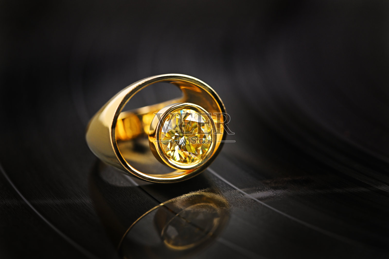 一枚中央有黄色宝石的金戒指照片摄影图片