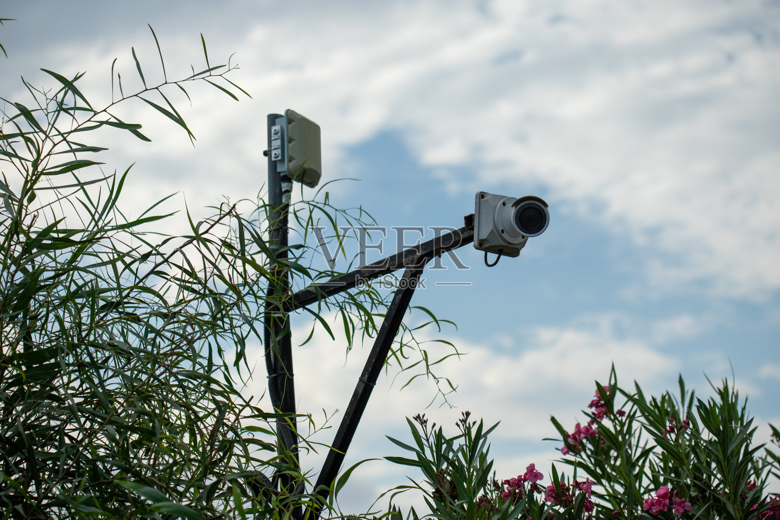 带有天空背景的杆子上的监控摄像头和天线照片摄影图片