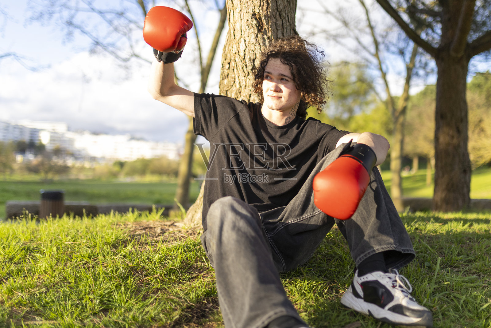 年轻男子在公园里戴着拳击手套庆祝成功照片摄影图片