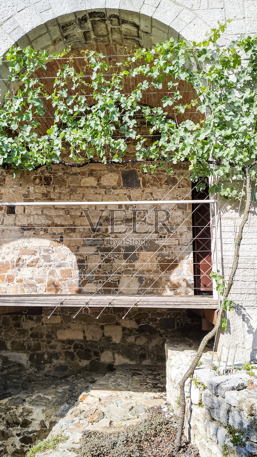 斯洛文尼亚卢布尔雅那的石墙与绿植和木阳台相结合，展现出乡村建筑的魅力。照片摄影图片