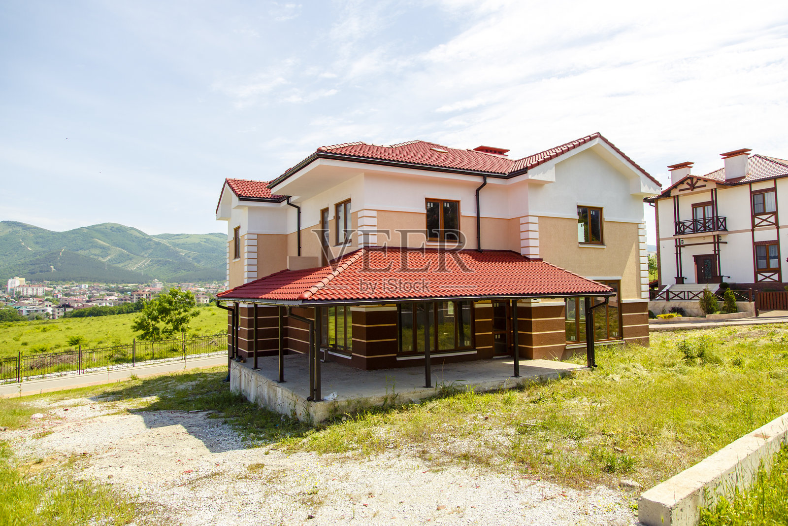 俄罗斯，格连吉克，2019年5月18日，一座红色屋顶的大房子坐落在草坡上照片摄影图片