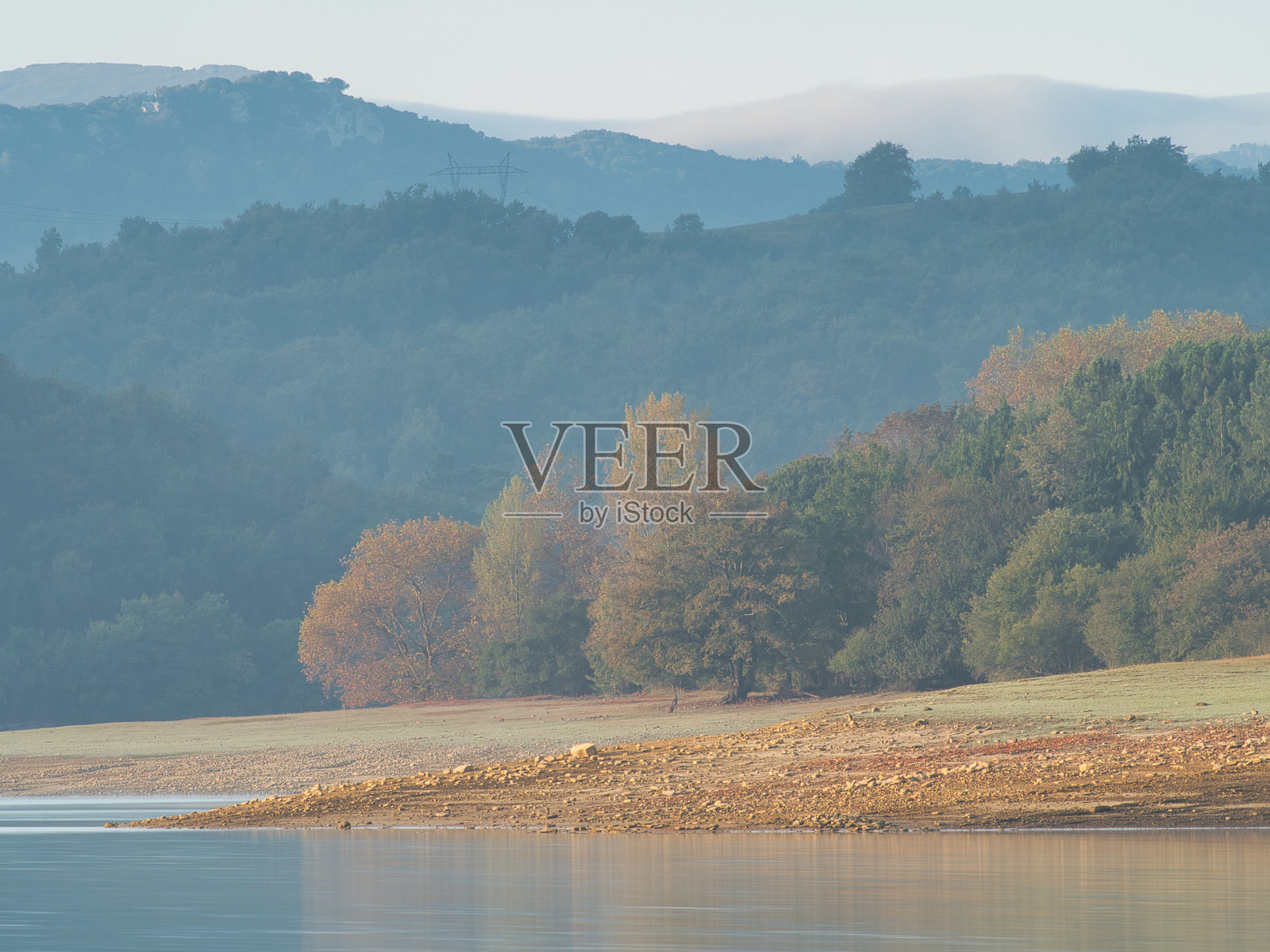 青苔覆盖的瀑布在郁郁葱葱的森林中流淌 - 一幅美丽的长时间曝光画面，展现了丝滑的瀑布在青苔覆盖的岩石和植物上流淌，周围是一片绿色的森林。照片摄影图片