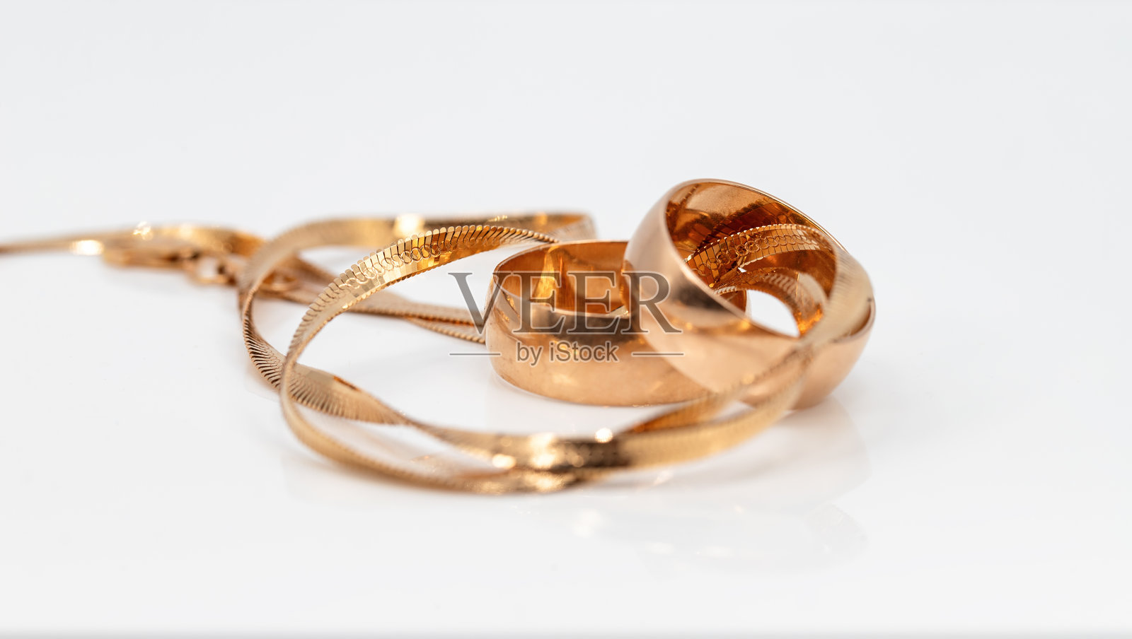 金色婚戒与编织手链照片摄影图片