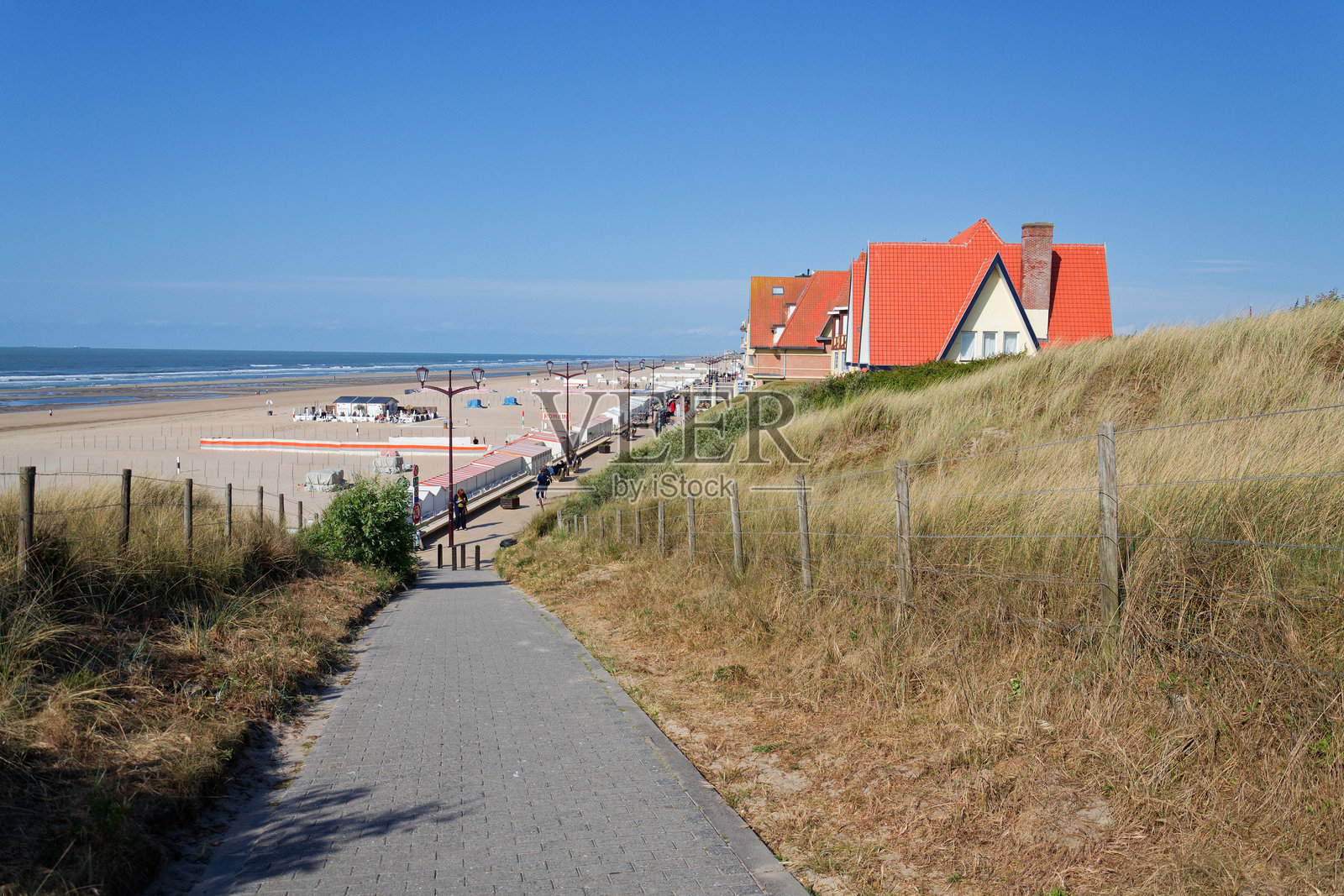 比利时德汉，2025年5月23日，阳光明媚的夏日，西弗拉芒省沿海村庄的沙滩上，人们在美丽的沙滩和沙丘附近。照片摄影图片