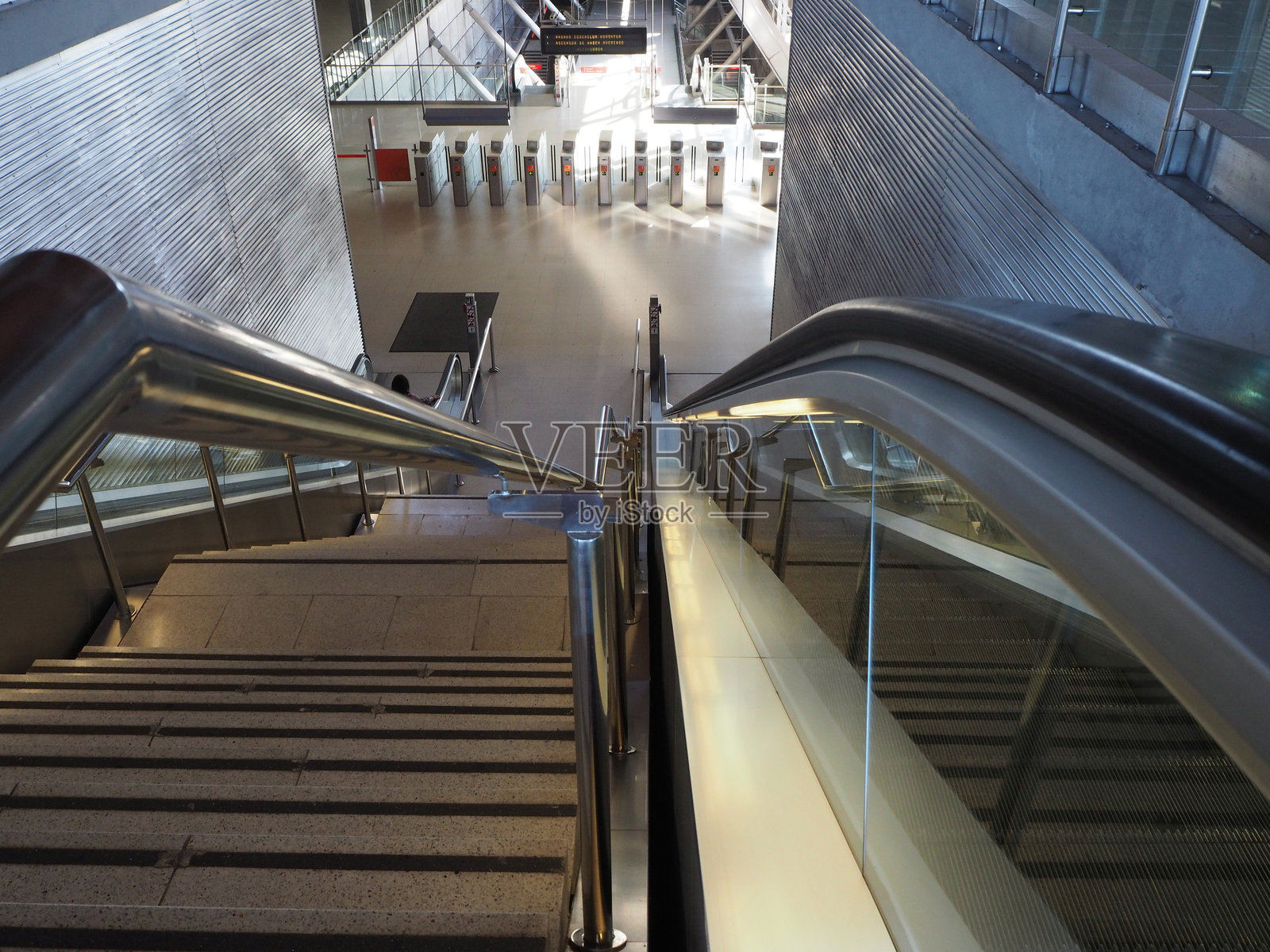 毕尔巴鄂地铁的自动扶梯和现代设计 - 从上往下俯瞰现代毕尔巴鄂地铁站内的自动扶梯和楼梯，突显其干净、未来感的建筑风格。照片摄影图片
