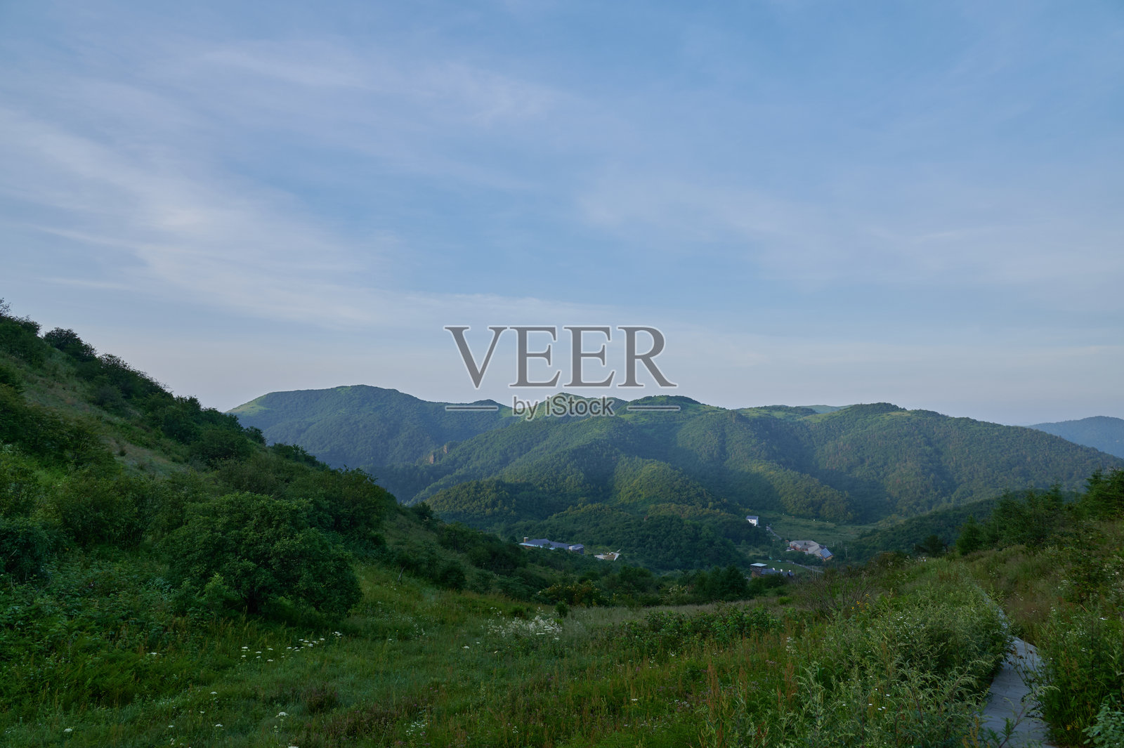 晴朗的日子里，蓝天下的青山绿谷照片摄影图片