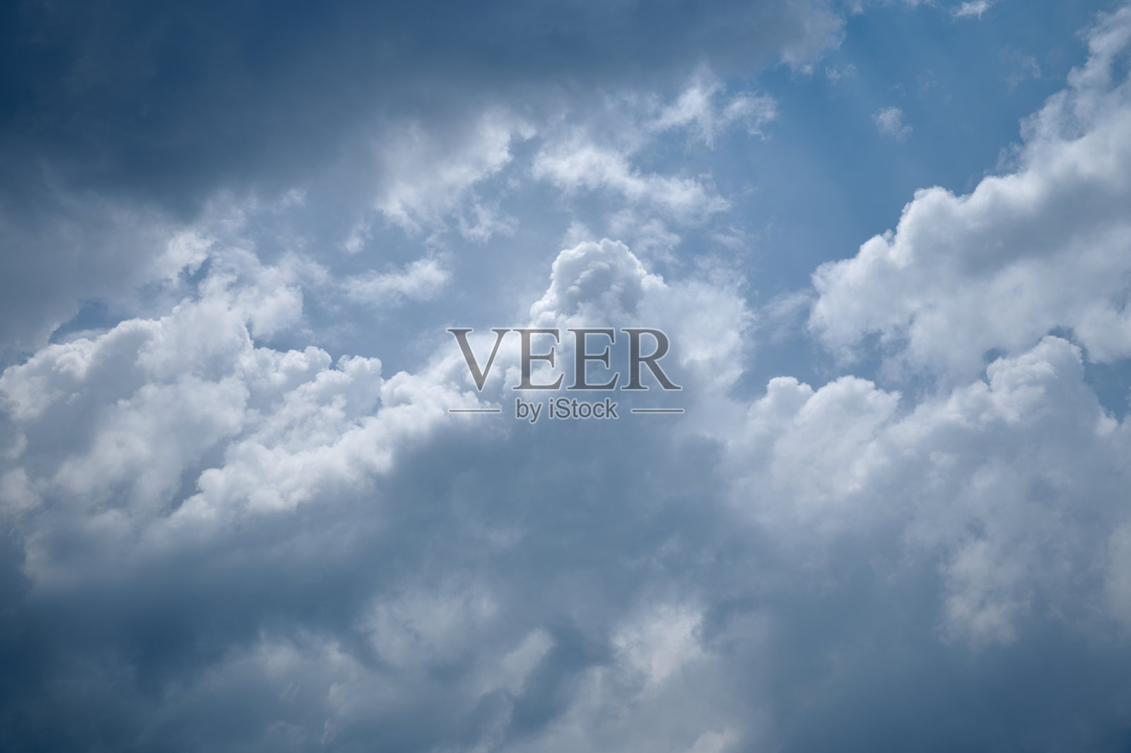 阳光明媚的日子里，白云在蓝天上形成。照片摄影图片