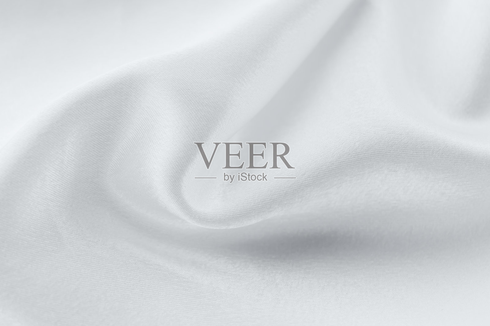 流动的白色面料特写，展现柔和的曲线和质感。照片摄影图片