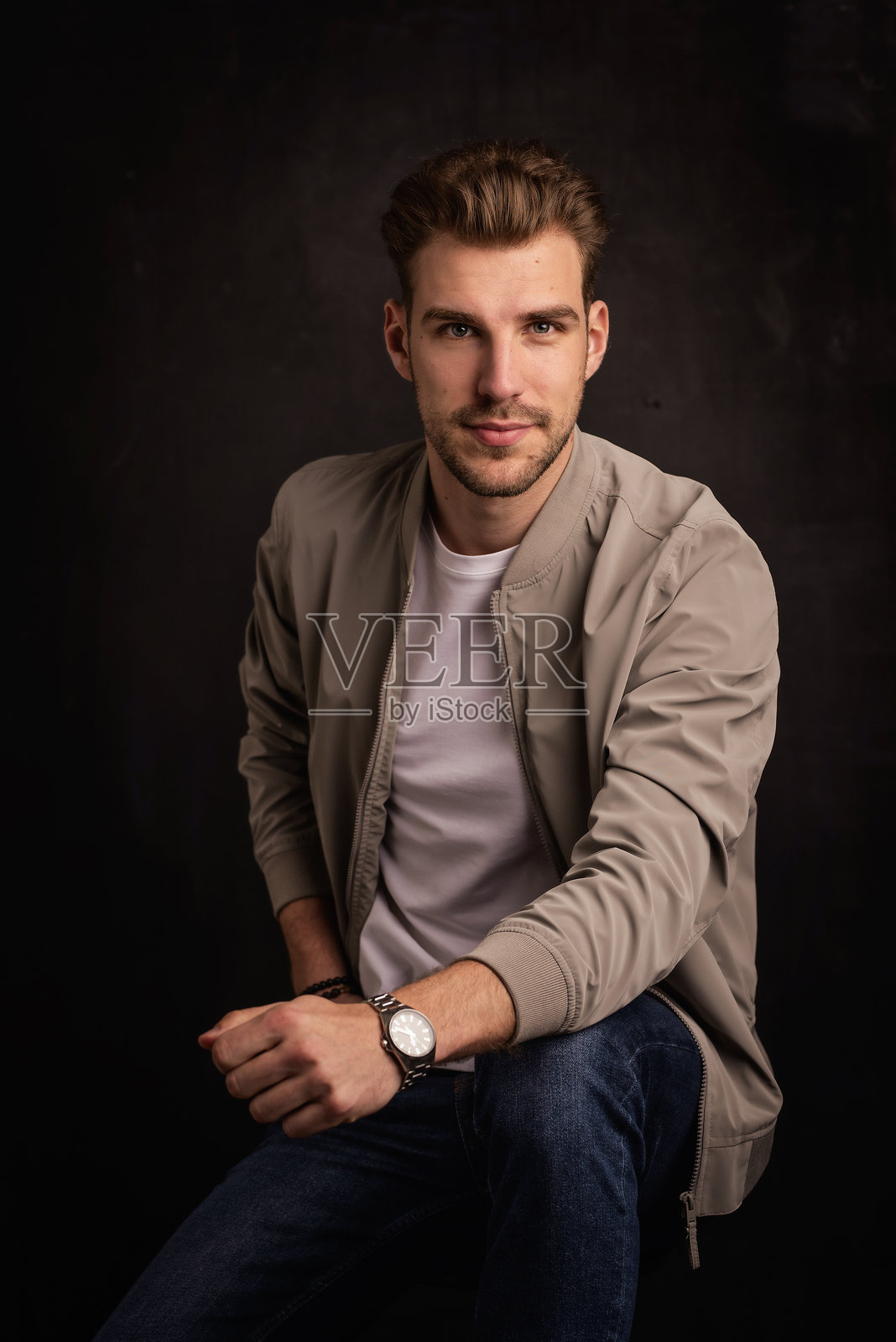 自信年轻男子的特写肖像，坐在孤立背景前照片摄影图片