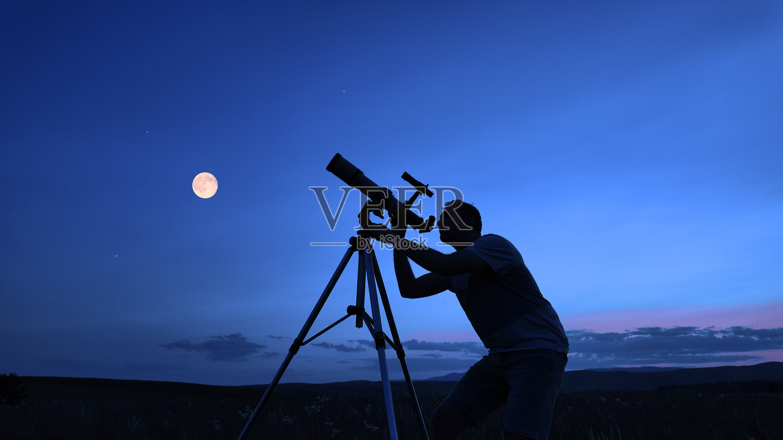 业余天文学家在自然田野中使用望远镜观察星星、月亮、行星和其他天体。照片摄影图片