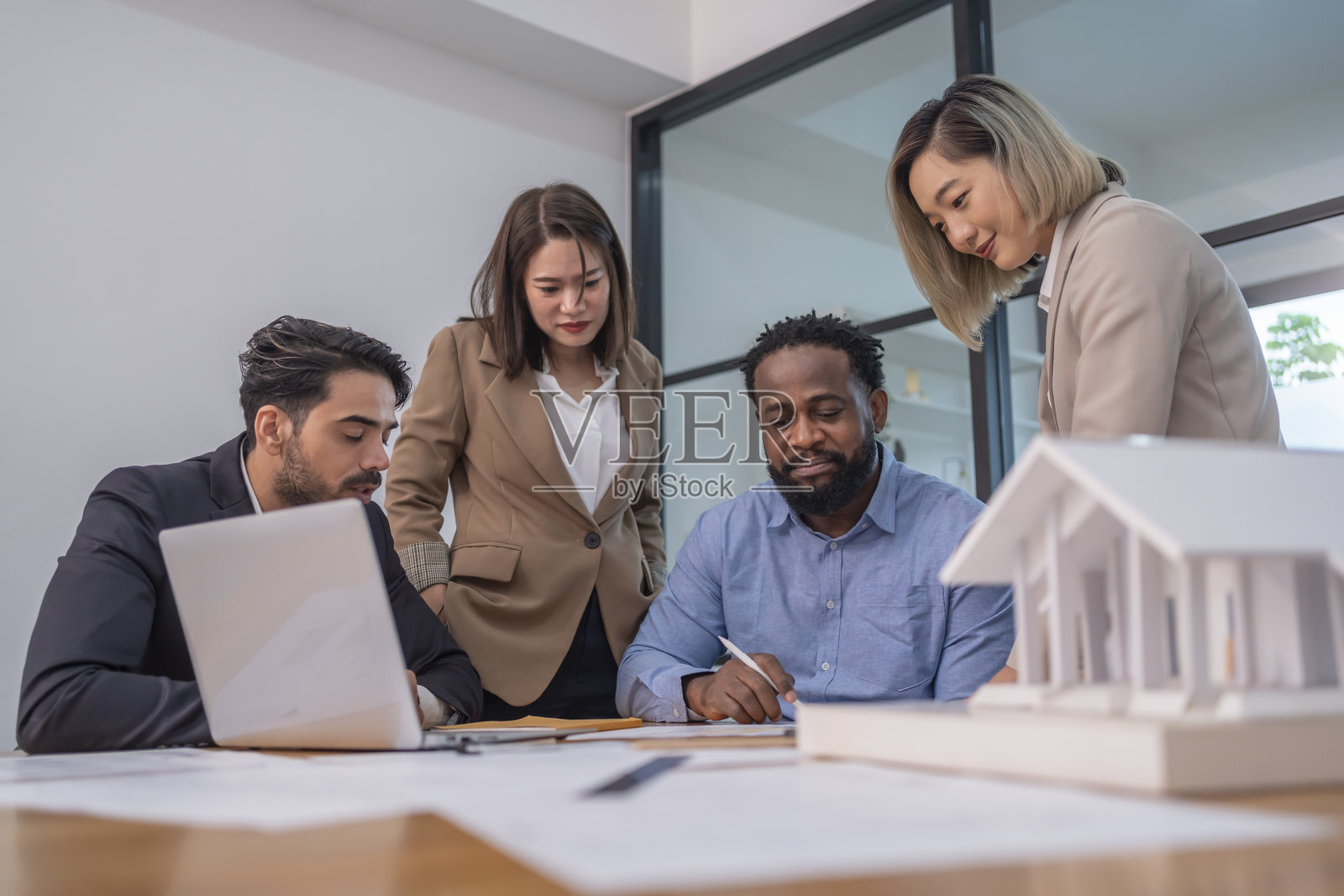 多种族商业团队，执行董事会成员在会议室的会议桌上讨论企业房地产投资。照片摄影图片