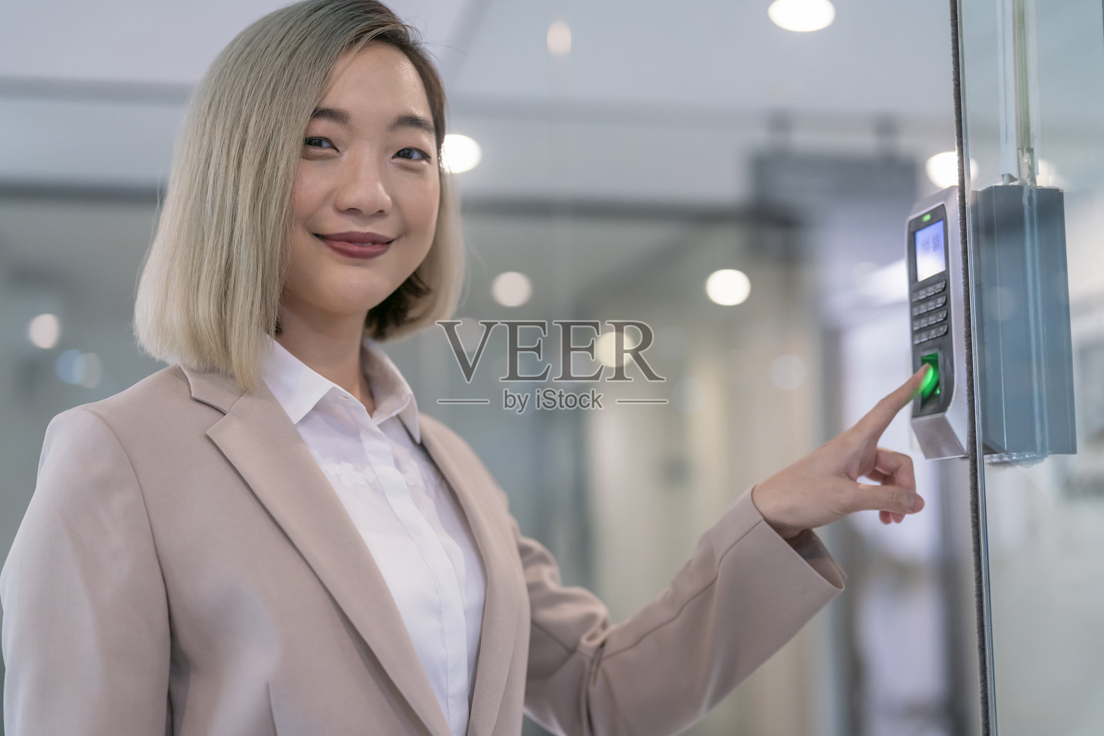 年轻亚洲女性公司员工使用生物识别指纹系统进行考勤和门禁管理的肖像照片摄影图片
