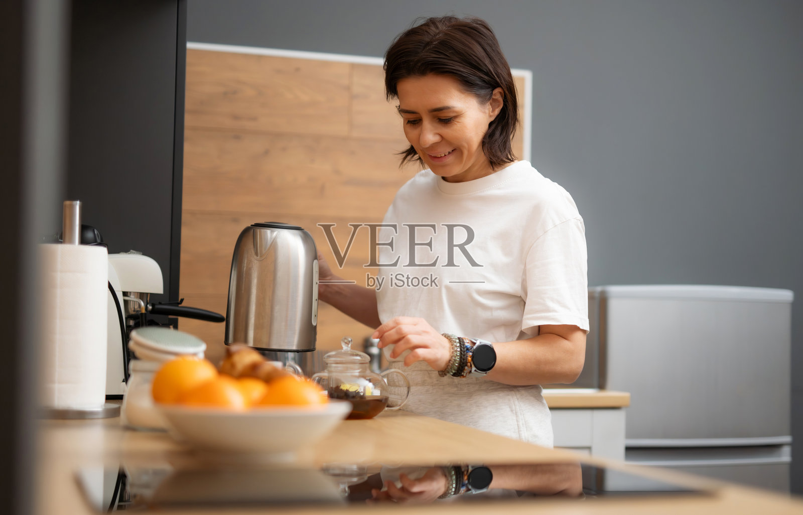 年轻女性正在锅中煮黑咖啡照片摄影图片