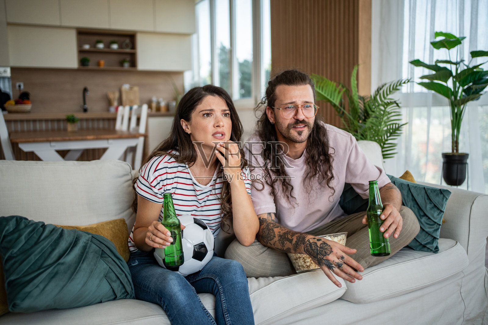 担心的夫妻在家看足球比赛照片摄影图片