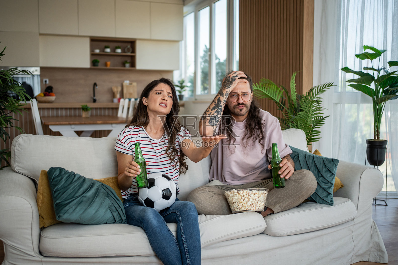 沮丧的情侣在家看足球比赛照片摄影图片