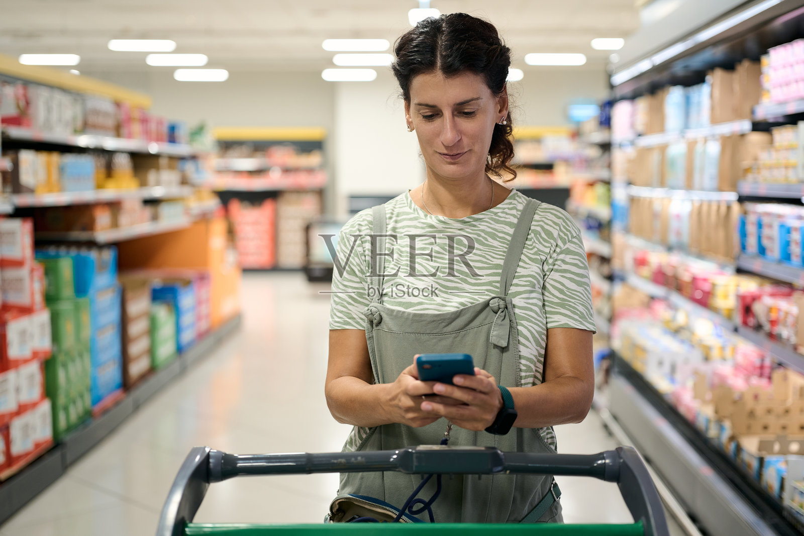 女性在超市购物时使用智能手机 - 经济危机与通货膨胀照片摄影图片