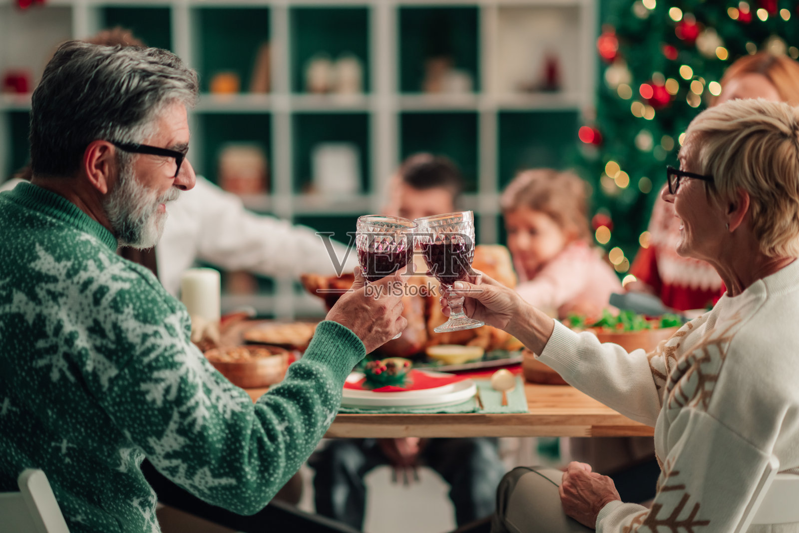 祖父母在圣诞晚餐上与家人举杯庆祝照片摄影图片