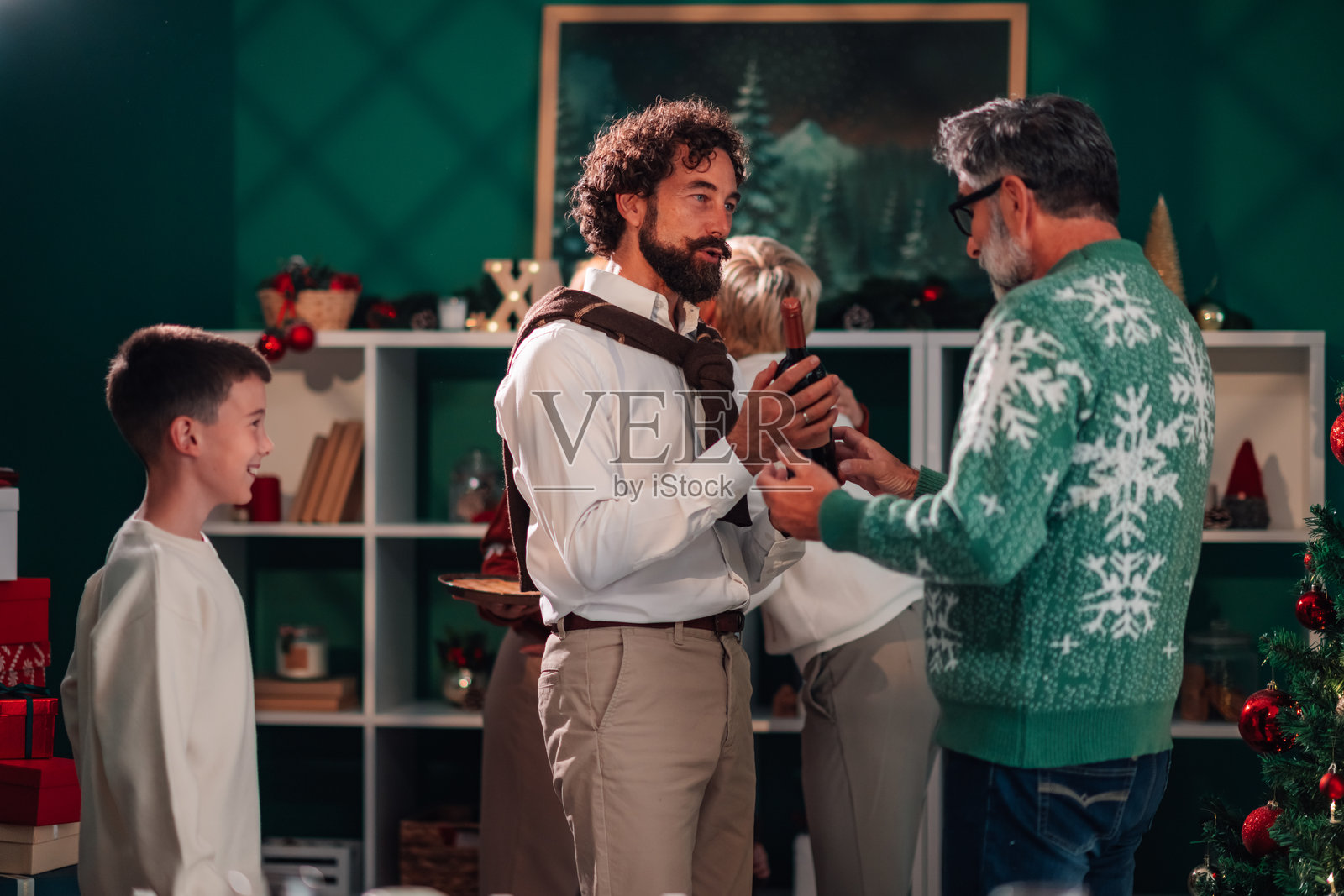 家庭庆祝圣诞节，互赠礼物和葡萄酒瓶照片摄影图片