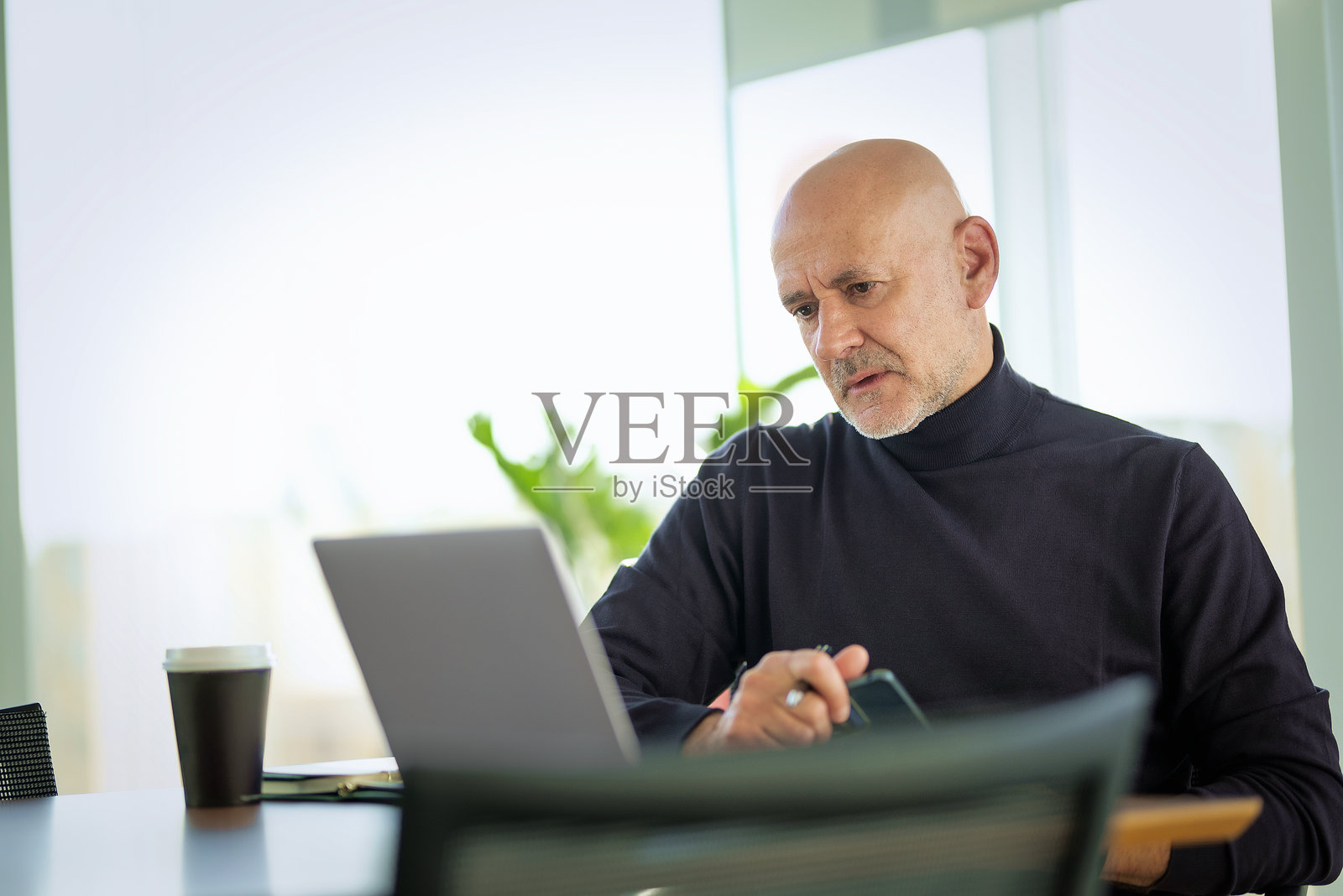 中年商人在现代办公室使用笔记本电脑工作照片摄影图片
