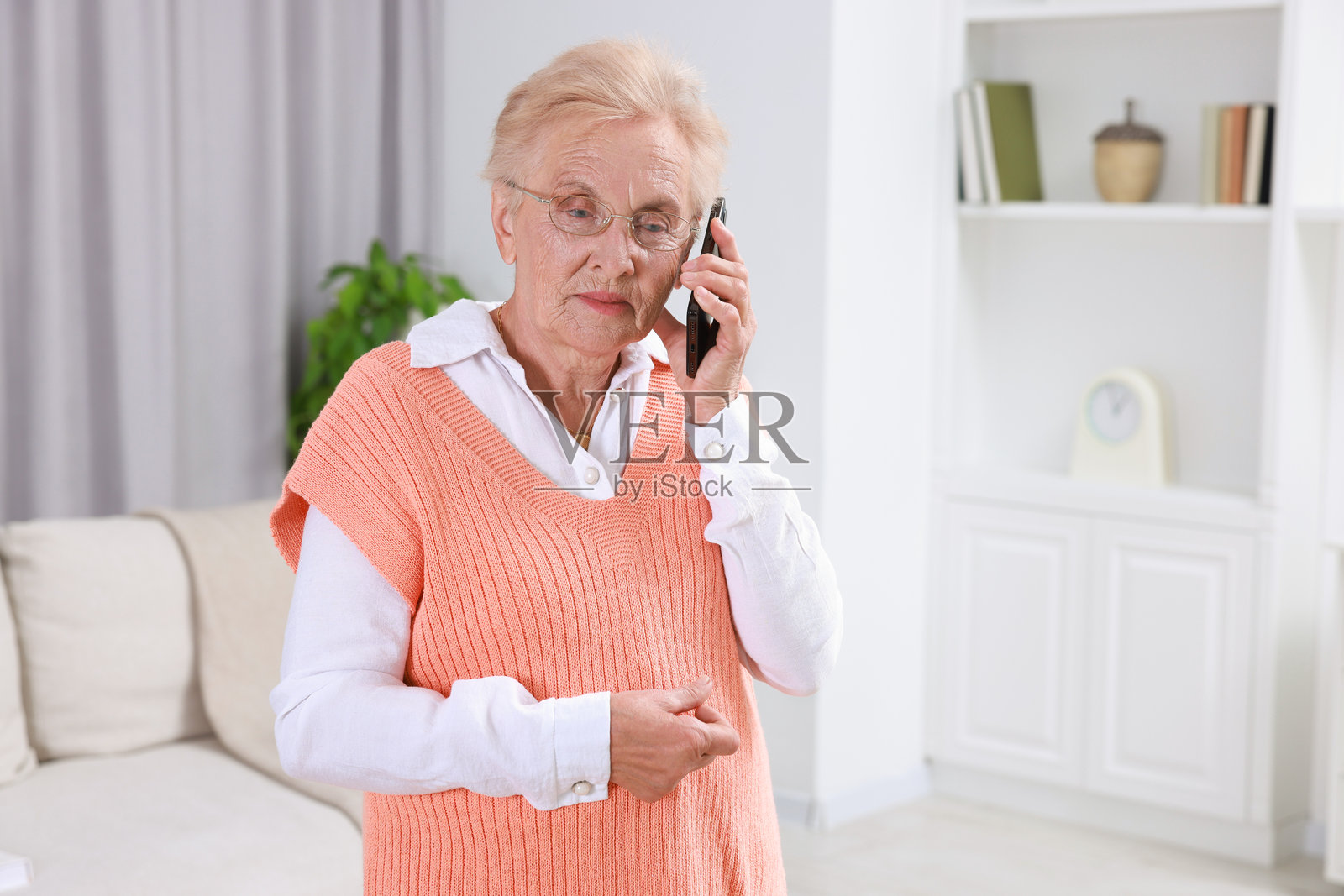 老年女性在家中打电话。留有文本空间。照片摄影图片