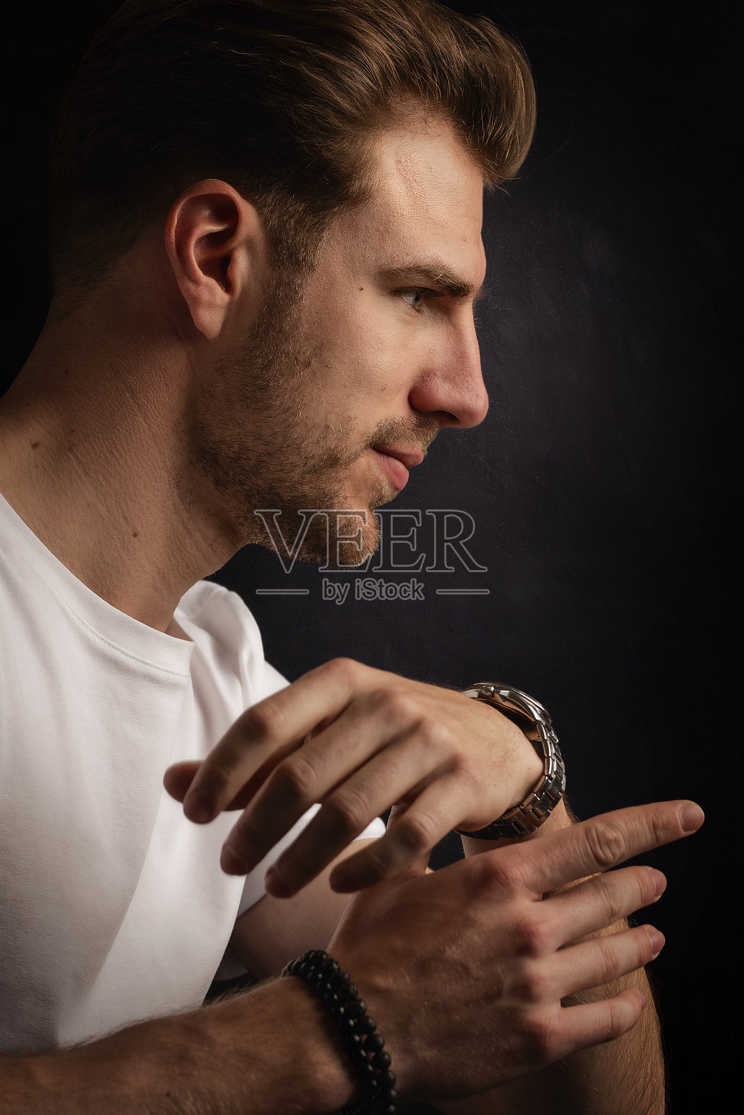 年轻男子的头像，背景为纯黑色照片摄影图片