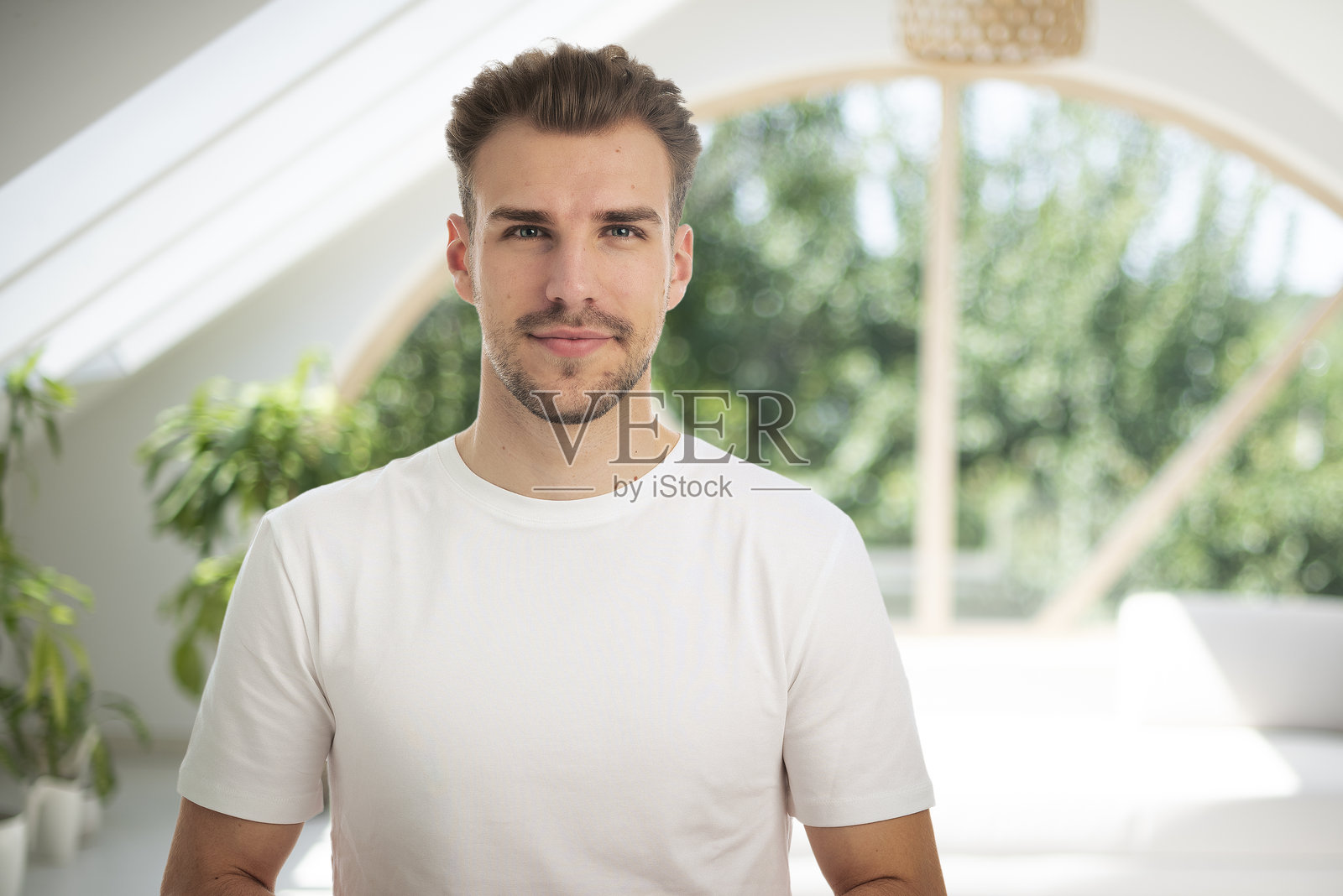 自信的年轻男子在窗边的肖像照片摄影图片